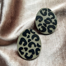 Load image into Gallery viewer, Handcrafted earrings made from smooth beige leather with a bold, hand-cut black leopard pattern, featuring a dynamic shape for a sleek and modern look. Lightweight and versatile, perfect for an edgy yet refined style.