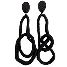 Load image into Gallery viewer, Crafted for bold style, these earrings feature a flexible wire wrapped in soft black leather, creating a unique design. With a long dangle-wrap style, they add drama to any outfit, while remaining lightweight for all-day comfort. The black leather wrapping adds texture and sophistication, offering an edgy yet elegant touch to your look.