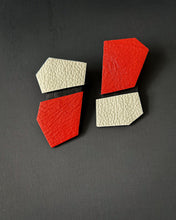 Load image into Gallery viewer, Modern, handcrafted leather earrings with bold angular shapes in a mix of bright red and off-white, highlighting their lightweight yet statement-making design.