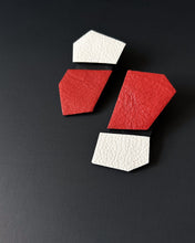 Load image into Gallery viewer, Modern, handcrafted leather earrings with bold angular shapes in a mix of bright red and off-white, highlighting their lightweight yet statement-making design.