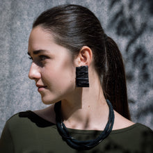 Load image into Gallery viewer, Three-layer elegant leather necklace featuring one strand of gleaming hematite beads and two strands of hand-cut black leather beads in varying sizes, emphasizing a sophisticated and mysterious appearance.