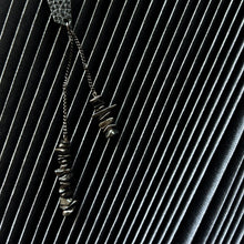 Load image into Gallery viewer, a pair of earrings designed for individuals seeking a unique and edgy accessory. The earrings are mismatched studs made from leather with a geometric shape. One earring features a simple stud design, while the other earring has a longer drop style with two black stainless chains of different lengths adorned with hematite stones.
