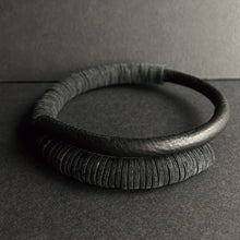 Load image into Gallery viewer, A close-up image of a Texture Fusion Leather Choker featuring a blend of leather textures, smooth hand-stitched tube and punched leather disks displayed against a neutral background