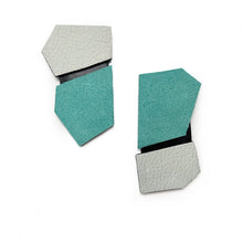 Load image into Gallery viewer, Statement leather earrings in turquoise, black, and white with sharp geometric angles, showcasing their structured design and contrasting textures.