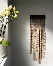 Load image into Gallery viewer, Minimalist wall hanging made of leather and wood, handcrafted and suspended, with freely hanging glossy leather strips catching light.