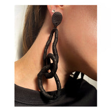 Load image into Gallery viewer, Crafted for bold style, these earrings feature a flexible wire wrapped in soft black leather, creating a unique design. With a long dangle-wrap style, they add drama to any outfit, while remaining lightweight for all-day comfort. The black leather wrapping adds texture and sophistication, offering an edgy yet elegant touch to your look.