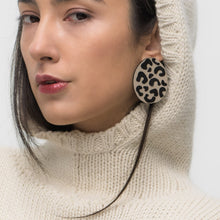 Load image into Gallery viewer, Handcrafted earrings made from smooth beige leather with a bold, hand-cut black leopard pattern, featuring a dynamic shape for a sleek and modern look. Lightweight and versatile, perfect for an edgy yet refined style.