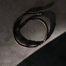 Load image into Gallery viewer, This genuine leather choker/bracelet hybrid lets you express your individuality and set your own standards of fashion. Wear it as a statement piece around your neck or wrist, or create customizable patterns for a unique look every time. Meticulously crafted with genuine leather wrapped around metal wire, this daring accessory is built to last. Be bold, be different, and let the Rebel Coil take your style to the next level.