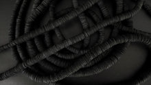 Load image into Gallery viewer, Elevate your style with our bold and modern extra-long necklace. Crafted with genuine leather disks ranging from 6-14mm and cotton waxed cord, it's a true statement piece that challenges the ideals of traditional accessories. Wear it as is or get creative by draping it around your waist or creating a crossed pattern. This disruptor of a necklace is sure to turn heads and start conversations. Shop now for a minimalistic yet eye-catching addition to your high-fashion wardrobe.