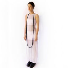 Load image into Gallery viewer, Elevate your style with our bold and modern extra-long necklace. Crafted with genuine leather disks ranging from 6-14mm and cotton waxed cord, it's a true statement piece that challenges the ideals of traditional accessories. Wear it as is or get creative by draping it around your waist or creating a crossed pattern. This disruptor of a necklace is sure to turn heads and start conversations. Shop now for a minimalistic yet eye-catching addition to your high-fashion wardrobe.