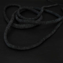 Load image into Gallery viewer, Elevate your style with our bold and modern extra-long necklace. Crafted with genuine leather disks ranging from 6-14mm and cotton waxed cord, it's a true statement piece that challenges the ideals of traditional accessories. Wear it as is or get creative by draping it around your waist or creating a crossed pattern. This disruptor of a necklace is sure to turn heads and start conversations. Shop now for a minimalistic yet eye-catching addition to your high-fashion wardrobe.