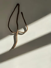 Load image into Gallery viewer, Handmade upcycled leather wall decor accent in the shape of a leaf, featuring a minimalist design with natural textures. Soft, lightweight and eco-friendly, this elegant piece adds a touch of sophistication to any room. Perfect for those who appreciate high-end design, it is an affordable luxury item that is easy to hang on any wall. A sustainable choice that showcases your commitment to eco-conscious living.