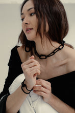 Load image into Gallery viewer, The contemporary design features flexible links that can be molded to create a serene or expressive look, adding a hint of deviance to a classic piece. The luxurious leather-wrapped links make it timeless and forever relevant. Chains symbolize our connections to others, the earth, and ourselves, making this necklace not only fashionable but also meaningful. Get creative with your styling and showcase the attractive closure. Don't miss out on this must-have accessory.