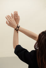 Load image into Gallery viewer, Anchor your style with the black leather bracelet. The wrapped leather adds texture and interest while the creative construction allows you to reshape the flexible links to your liking. The perfect addition to any outfit.