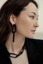 Load image into Gallery viewer, The contemporary design features flexible links that can be molded to create a serene or expressive look, adding a hint of deviance to a classic piece. The luxurious leather-wrapped links make it timeless and forever relevant. Chains symbolize our connections to others, the earth, and ourselves, making this necklace not only fashionable but also meaningful. Get creative with your styling and showcase the attractive closure. Don't miss out on this must-have accessory.