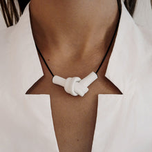 Load image into Gallery viewer, Elevate your style with a leather knot pendant necklace - a symbol of eternal connection and cherished bonds. With modern sophistication and impeccable hand craftsmanship, this necklace showcases the fine qualities of leather. Available in two lengths, it's functional art with a meaning, making it the perfect gift for yourself or a loved one. Choose the shorter length for a flattering collarbone accent or the longer length to wear over your heart.