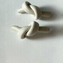 Load image into Gallery viewer, Handcrafted Leather knot stud earrings - a symbol of eternal connection and cherished bond. These earrings offer the perfect amount of visual interest for a flattering and pronounced presence, adding simple sophistication whether you're dressed up or down. The luxurious feel and suppleness of the fine leather is something to be admired, and the subtle colour-matched stitching reveals impeccable hand craftsmanship. Feel anchored with the knot and enjoy the timeless elegance of these earrings.