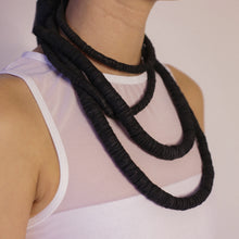 Load image into Gallery viewer, Elevate your style with our bold and modern extra-long necklace. Crafted with genuine leather disks ranging from 6-14mm and cotton waxed cord, it's a true statement piece that challenges the ideals of traditional accessories. Wear it as is or get creative by draping it around your waist or creating a crossed pattern. This disruptor of a necklace is sure to turn heads and start conversations. Shop now for a minimalistic yet eye-catching addition to your high-fashion wardrobe.