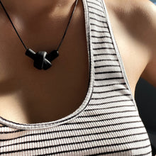 Load image into Gallery viewer, Elevate your style with a leather knot pendant necklace - a symbol of eternal connection and cherished bonds. With modern sophistication and impeccable hand craftsmanship, this necklace showcases the fine qualities of leather. Available in two lengths, it's functional art with a meaning, making it the perfect gift for yourself or a loved one. Choose the shorter length for a flattering collarbone accent or the longer length to wear over your heart.