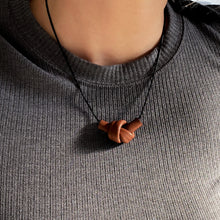 Load image into Gallery viewer, Elevate your style with a leather knot pendant necklace - a symbol of eternal connection and cherished bonds. With modern sophistication and impeccable hand craftsmanship, this necklace showcases the fine qualities of leather. Available in two lengths, it's functional art with a meaning, making it the perfect gift for yourself or a loved one. Choose the shorter length for a flattering collarbone accent or the longer length to wear over your heart.