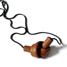 Load image into Gallery viewer, Elevate your style with a leather knot pendant necklace - a symbol of eternal connection and cherished bonds. With modern sophistication and impeccable hand craftsmanship, this necklace showcases the fine qualities of leather. Available in two lengths, it's functional art with a meaning, making it the perfect gift for yourself or a loved one. Choose the shorter length for a flattering collarbone accent or the longer length to wear over your heart.