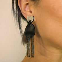 Load image into Gallery viewer, Discover our &#39;Affinity&#39; Black Leather Earrings. These earrings combine sleek black leather in a stud-style semicircle and an elongated oval pendant adorned with delicate chains. The design balances modern allure and timeless charm. Perfect for formal occasions or adding a touch of noir luxury. Lightweight and elegant, these earrings embody sophistication in motion