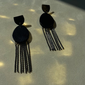 Discover our 'Affinity' Black Leather Earrings. These earrings combine sleek black leather in a stud-style semicircle and an elongated oval pendant adorned with delicate chains. The design balances modern allure and timeless charm. Perfect for formal occasions or adding a touch of noir luxury. Lightweight and elegant, these earrings embody sophistication in motion