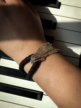 Load image into Gallery viewer, Hand with a bracelet on a piano keyboard