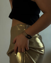 Load image into Gallery viewer, Person wearing a black top and gold skirt with bracelets on a plain background