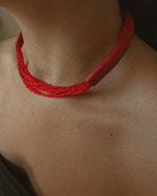 Load image into Gallery viewer, A choker that pairs hand-stitched leather with cascading strands of glass beads. The tubular leather form gives it presence, while the beads add fluid movement in a striking red. Lightweight and adjustable, made for moments that stand out.