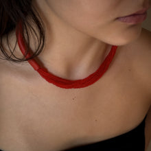 Load image into Gallery viewer, A choker that pairs hand-stitched leather with cascading strands of glass beads. The tubular leather form gives it presence, while the beads add fluid movement in a striking red. Lightweight and adjustable, made for moments that stand out.