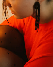 Load image into Gallery viewer, Close-up of a person wearing brown long beaded leather  earrings and a red garment with a neutral background