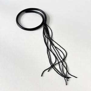 Black leather choker with black beaded tassel, showcasing a versatile design that can be worn in multiple ways.