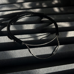 Close-up of a handcrafted leather choker featuring smooth black leather and delicate silver Japanese glass beads, creating a bold yet elegant minimalist design