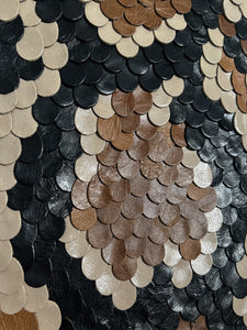 Handcrafted wall art made from upcycled leather, featuring a snakeskin-inspired design with individually hand-punched scales in earthy tones, perfect for adding texture and sustainability to modern interiors.