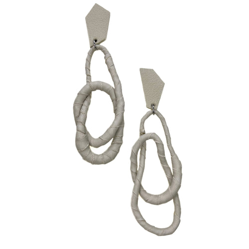 Image of a pair of Ivory Geo Flex Earrings, featuring asymmetric geometric studs wrapped in luxurious off-white leather.