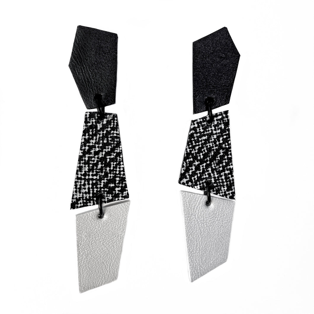 Sleek, asymmetrical leather earrings featuring three geometric shapes in crisp white, bold black, and a striking black-and-white pattern. Perfect for adding a contemporary and dynamic touch to any ensemble, crafted for those who appreciate clean lines and modern design.