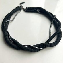 Load image into Gallery viewer, Three-layer elegant leather necklace featuring one strand of gleaming hematite beads and two strands of hand-cut black leather beads in varying sizes, emphasizing a sophisticated and mysterious appearance.