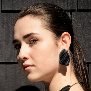 Striking black leather earrings with unique organic shapes, handcrafted from premium upcycled leather. Each pair combines smooth and textured surfaces for a visually contrasting design, ideal for adding a chic, eco-conscious touch to any outfit.
