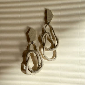 Image of a pair of Ivory Geo Flex Earrings, featuring asymmetric geometric studs wrapped in luxurious off-white leather.