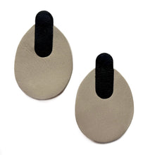 Load image into Gallery viewer, Minimalist leather earrings in soft beige and black, featuring a modern, oval shape with a sleek, layered design. Lightweight and sustainably crafted for an effortless, sophisticated look.