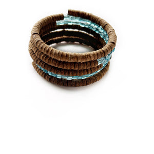 Wrap-around bracelet featuring earthy suede leather and shimmering Japanese beads in a layered design, showcasing a blend of texture and elegance. Lightweight and adjustable for a comfortable fit.