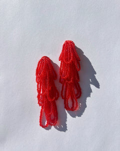 Cascading red beaded earrings with hand‑stitched strands on a leather base, handmade by WAIWAI.