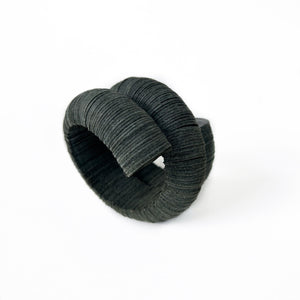 Handcrafted bracelet made from upcycled leather in a rich brown tone, featuring a sculptural and layered design with a unique spiral form.