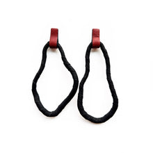 Load image into Gallery viewer, A pair of reshapable earrings handcrafted from black leather with a textured finish, forming irregular looped shapes, accented by bold red leather connectors. Lightweight and versatile for unique styling.