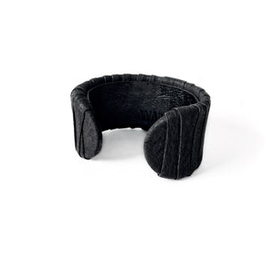 A handcrafted black leather cuff bracelet featuring a ridged texture and a minimal design