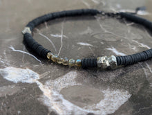 Load image into Gallery viewer, Handcrafted necklace featuring black leather discs, labradorite stones with iridescent sheen, and metallic pyrite gemstones, designed with a bold and modern aesthetic.