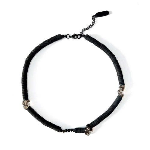 Handcrafted necklace featuring black leather discs, glossy obsidian stones, and translucent smoky quartz gemstones, designed with a bold and modern aesthetic.