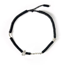 Load image into Gallery viewer, Handcrafted necklace featuring black leather discs, freshwater pearls, and clear quartz gemstones, designed with a modern, tactile aesthetic.