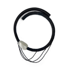 Load image into Gallery viewer, A handcrafted choker featuring a smooth white jade stone, stainless steel chains draping elegantly, a hand-stitched leather tube on one side, and individually hand-punched leather discs on the other. This bold and modern design combines texture and craftsmanship for a striking statement piece.
